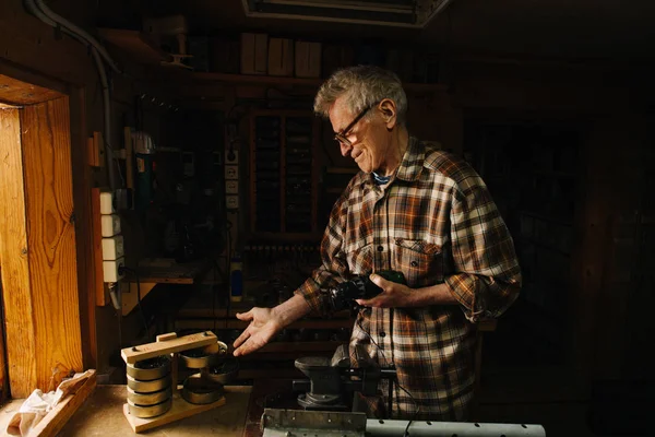 Amateur carpintero senior en su taller, mostrando alrededor —  Fotos de Stock