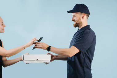 Kadın bir akıllı telefon üzerinde imzalayarak bir kurye bir kutu teslimat kabul ediyor