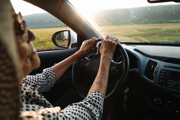 Alte Frau hält Hand am Rad — Stockfoto