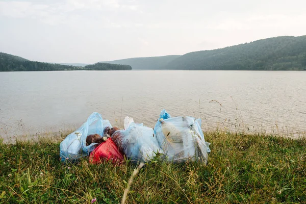 Botellas de plástico y vidrio en la bolsa de basura en el fondo del río — Foto de Stock