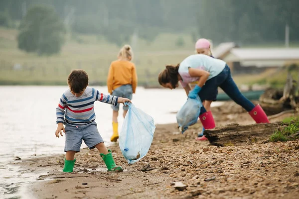 Niño coleccionando basura con un grupo de niños — Foto de Stock