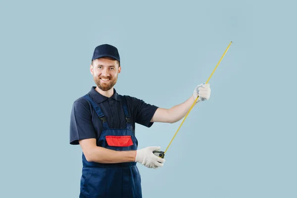 Retrato de trabalhador de serviço alegre com fita métrica em mãos vestidas de uniforme — Fotografia de Stock