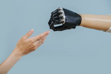 artificial limb and female hand stretch to each other clipart