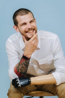 yapay el ile mutlu sakallı adam uzağa bakar ve gülümsüyor
