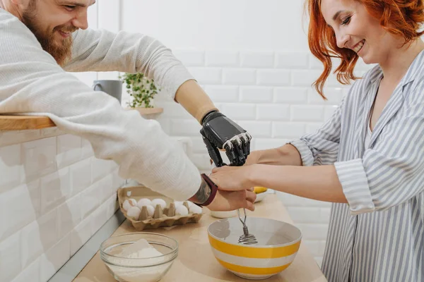 Ein junger Mann mit künstlichen Gliedmaßen kocht mit seiner Freundin in der Küche — Stockfoto