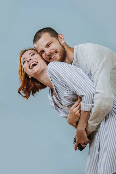 Hombre con extremidades artificiales abraza a su novia desde la espalda y se ríen —  Fotos de Stock
