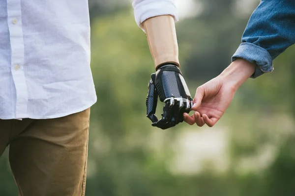 Primo piano colpo di uomo con un arto protesico tenendo le mani con partner femminile Immagine Stock
