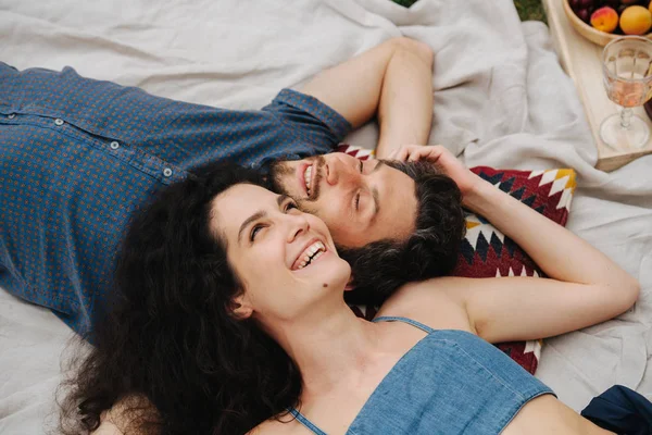 Koppel in de liefde, genieter elkaars gezelschap tijdens picknick op gazon Rechtenvrije Stockfoto's