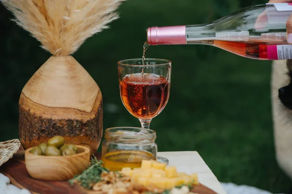 Vino de rosas, vertiendo de la botella en el vaso hasta que esté lleno . — Foto de Stock