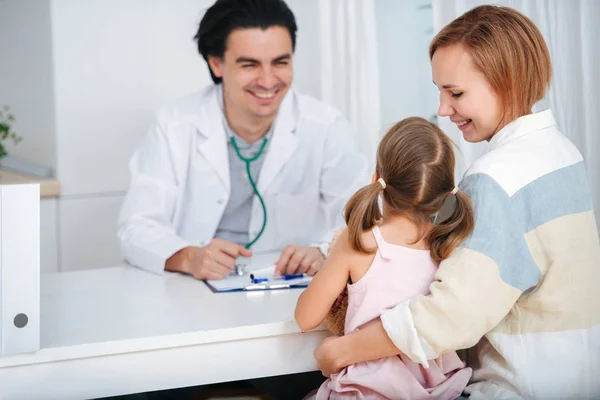 Médecin souriant parlant à, remonter le moral de son petit patient . — Photo