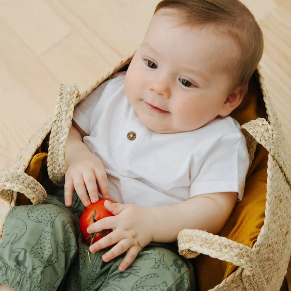 Infant baby is sitting in a woolven like bag — Stock Photo, Image