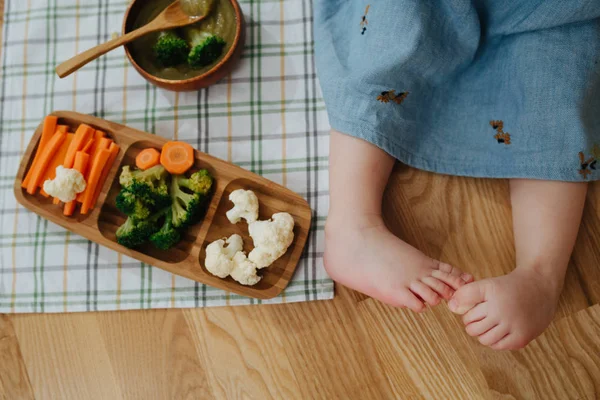 Маленька дівчинка і тарілка з овочами — стокове фото