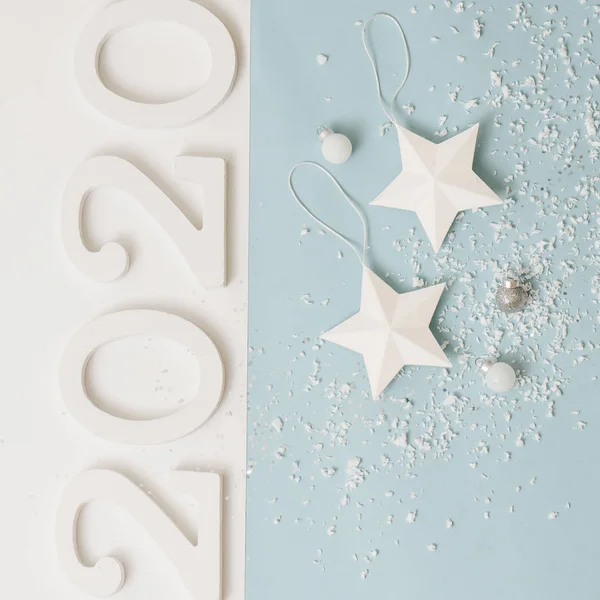 Beyaz noel ağacı yıldız ve topları mavi üzerinde kar taklidi serpilir — Stok fotoğraf
