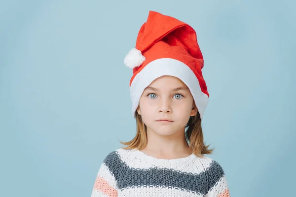 Porträt eines süßen kleinen Erstklässlers mit Weihnachtsmütze und Strickpullover. — Stockfoto