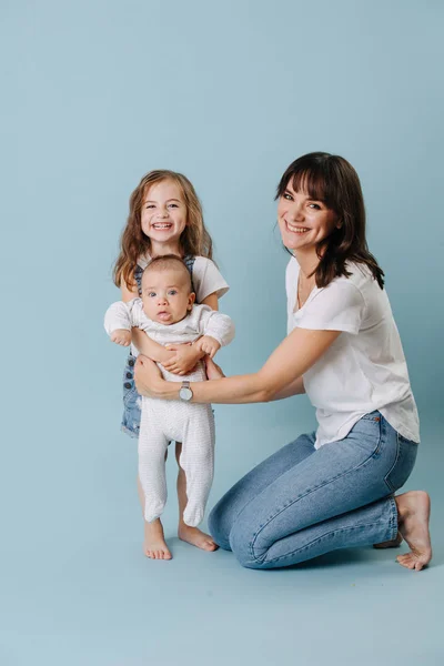 Familie portret van een moeder met twee dochters over blauwe achtergrond — Stockfoto