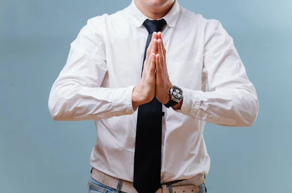 Hombre de negocios con camisa blanca uniendo sus manos, haciendo un gesto de oración sobre azul — Foto de Stock