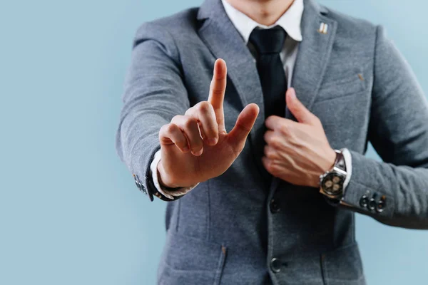 Empresario en traje haciendo gesto de objeción, sosteniendo el dedo índice sobre azul — Foto de Stock