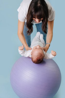 Mutlu anne mor yoga topu onu bebek bebek ile egzersiz yapıyor