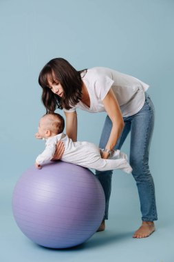 Mutlu anne mor yoga topu onu bebek bebek ile egzersiz yapıyor