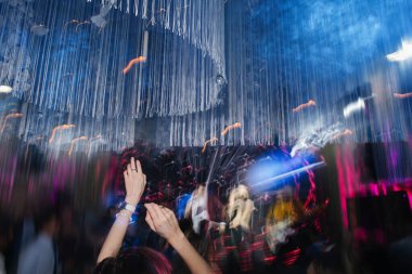 Rock grubu bir kalabalığın önünde konser sırasında müzik çalıyor. Hareket bulanık