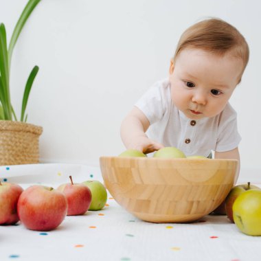 Küçük çocuk kaseden bir elma çıkardı.