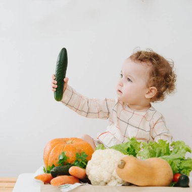 Bebeğin salatalıkla oynadığı kare yakın çekim.