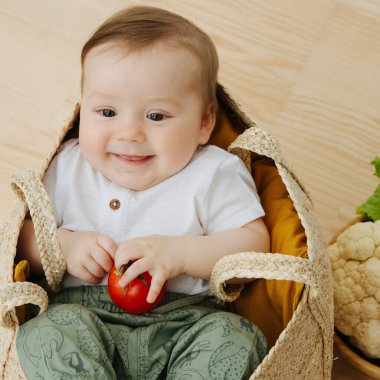 Bebek bebek, yakındaki sebze torbası ve kase gibi yünlü