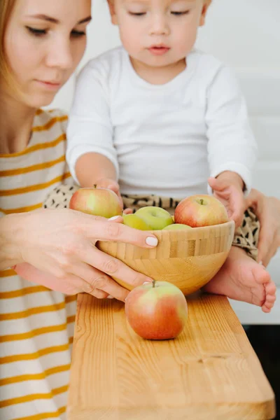 Блондинка-малюк досліджує, грає з яблуками з обв'язки . — стокове фото