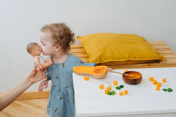 Curly girl made a break to kiss doll — Stock Photo, Image