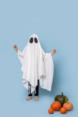 Mavi stüdyoda poz veren balkabaklı bir hayalet.