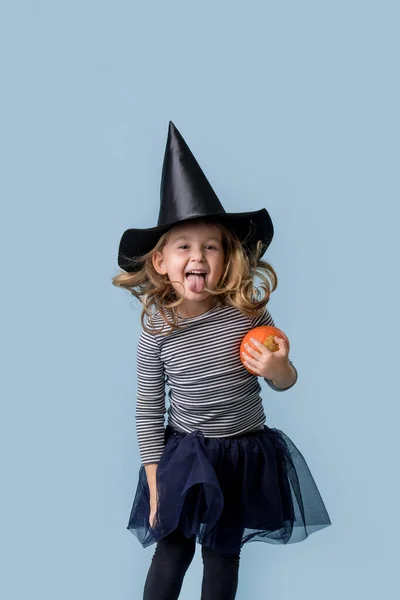 Holčička s dýní v rukou a v kostýmu čarodějnice — Stock fotografie