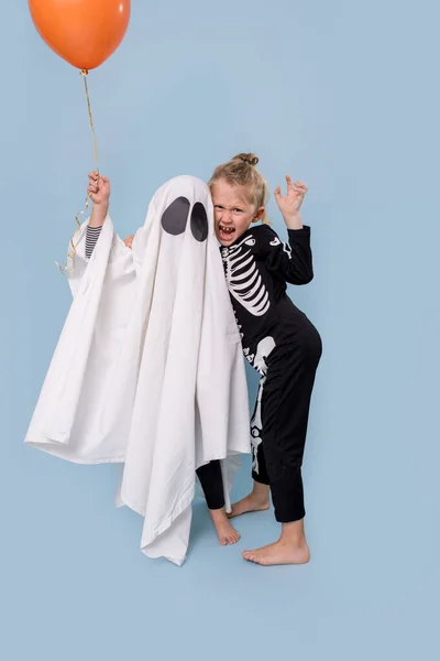 I bambini in costume da fantasma e scheletro ad Halloween si divertono in studio — Foto Stock