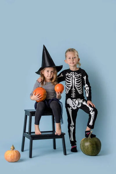 Doppio ritratto di fratello e sorella in costume di Halloween con zucche . — Foto Stock