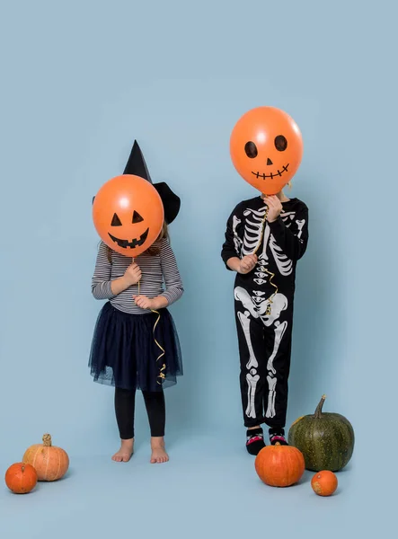 I bambini in costumi di Halloween coprono scherzosamente i loro palloncini facciali — Foto Stock