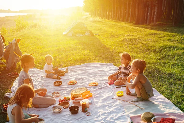 Çocuklar Çimenlerde Piknik Yapıyor Battaniyeye Oturuyor Yemek Yiyorlar Yumuşak Batan — Stok fotoğraf