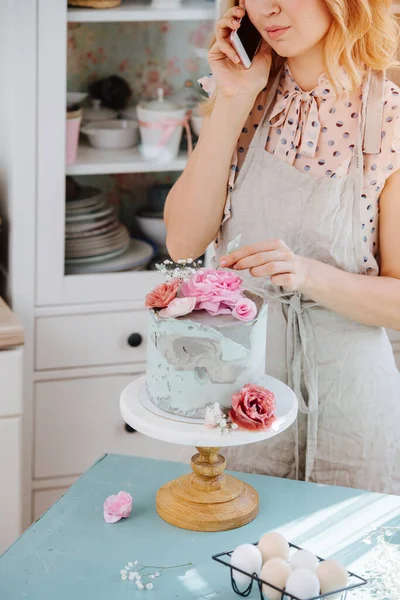 Hanımı Telefonda Konuşurken Tatlı Bir Pasta Tepesine Dekoratif Çiçekler Koyuyor — Stok fotoğraf