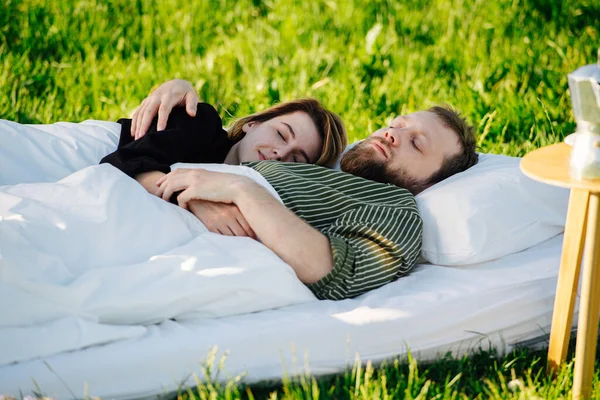 Duas pessoas descansando na cama feitas fora em uma grama, boa sesta feliz — Fotografia de Stock