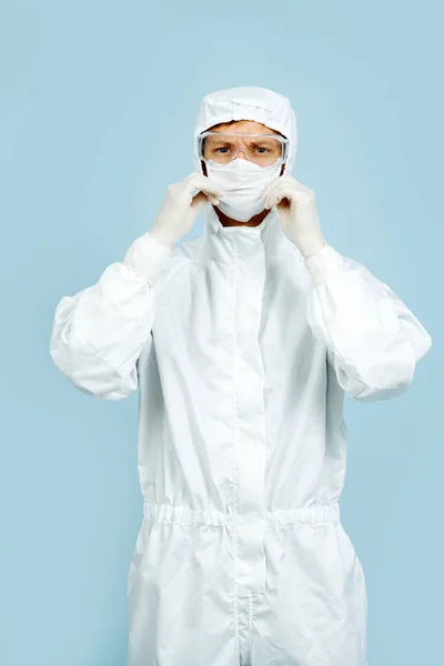 Doutor em um traje branco cobrindo toda a pele, usando máscara, luvas e óculos — Fotografia de Stock
