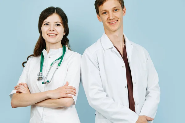 Retrato de dois jovens médicos vestindo vestes brancas. Homem e mulher . — Fotografia de Stock