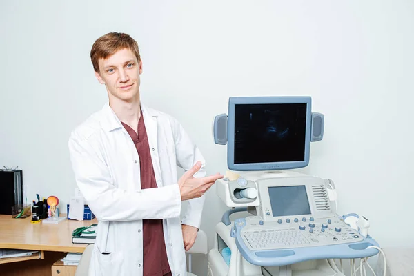 Jeune médecin pointant à la main ouverte à la machine à échographie — Photo