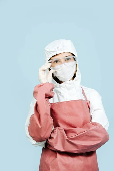 Cirurgião de traje branco cobrindo toda a pele vestindo avental e mangas de couro vermelho — Fotografia de Stock