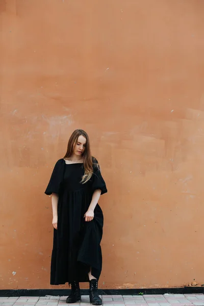 Mulher Nova Vestido Preto Longo Botas Pesadas Frente Uma Parede — Fotografia de Stock