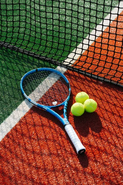 コートの外側のクリアランス部分の間の行に横に青色のテニスラケットネットの横にある — ストック写真