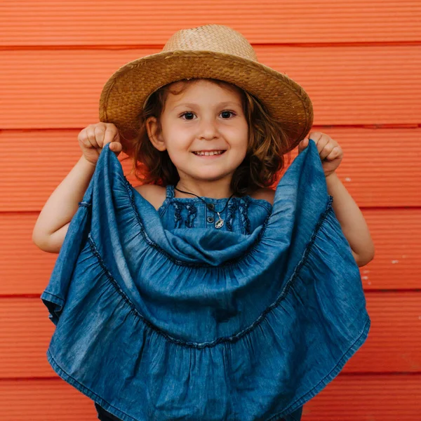 Niña Feliz Sombrero Verano Hermoso Vestido Azul Contra Pared Roja — Foto de Stock