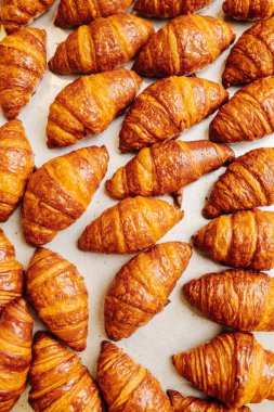 Yeni pişmiş altın kruvasan yüzeyde soğuyor. üstten çekim