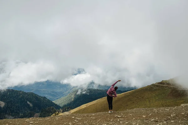 Длинный Снимок Молодой Женщины Делающей Боковые Изгибы Упражняющейся Высоко Горах — стоковое фото