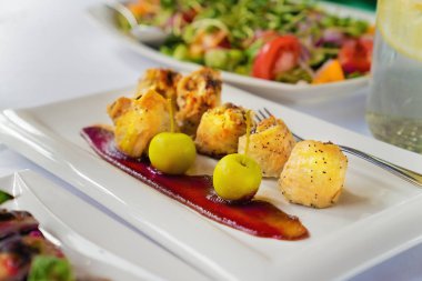 Bir tablo üzerinde beyaz bir tabakta tavuk göğsü rulo aples ve sos ile. Yakın çekim.