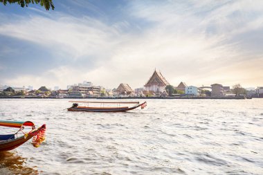Geleneksel Tay uzun kuyruk tekne Chao Phraya Nehri yakınında Wat Arun günbatımı, Bangkok, Tayland