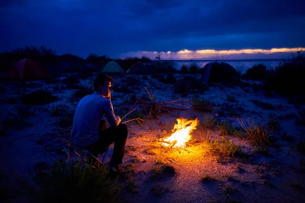 Uomo Guardando Falò Tenda Notte Sulla Spiaggia Del Lago — Foto Stock