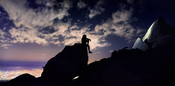 Άνθρωπος Dreadlocks Κάθεται Πάνω Στο Βράχο Στη Σιλουέτα Στο Νυχτερινό — Φωτογραφία Αρχείου
